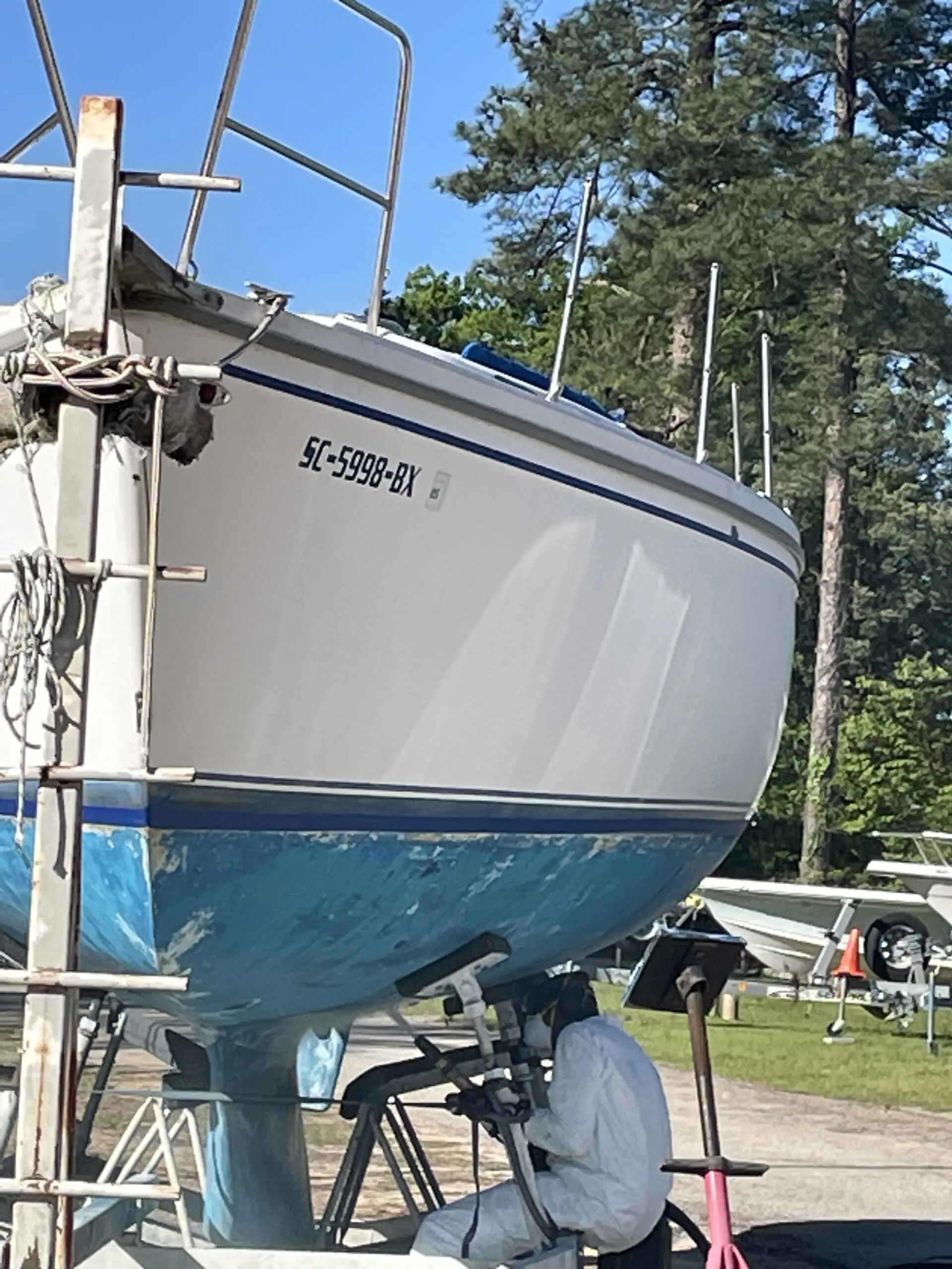 A boat is parked in the grass near some trees.