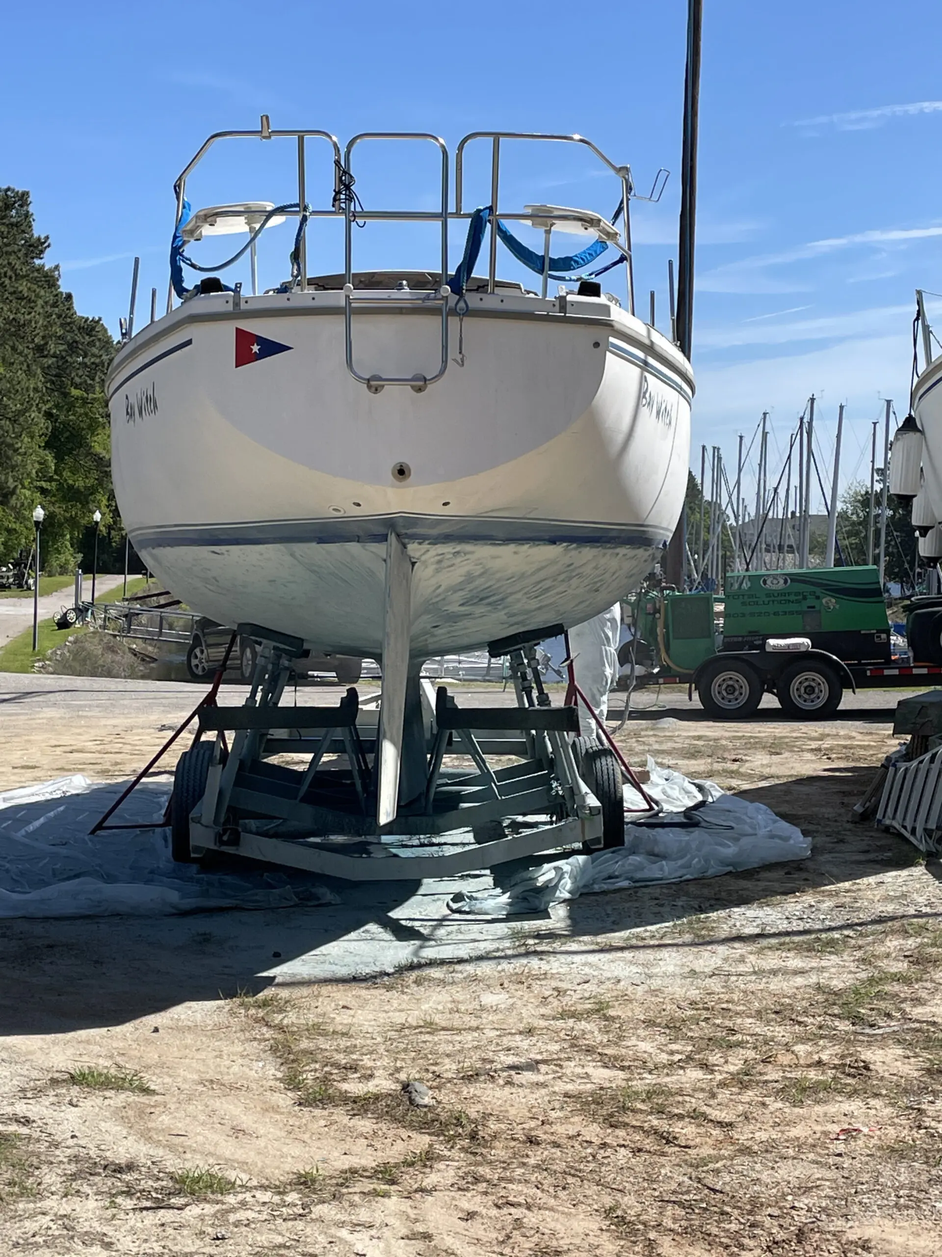 A boat is parked on the ground near other boats.
