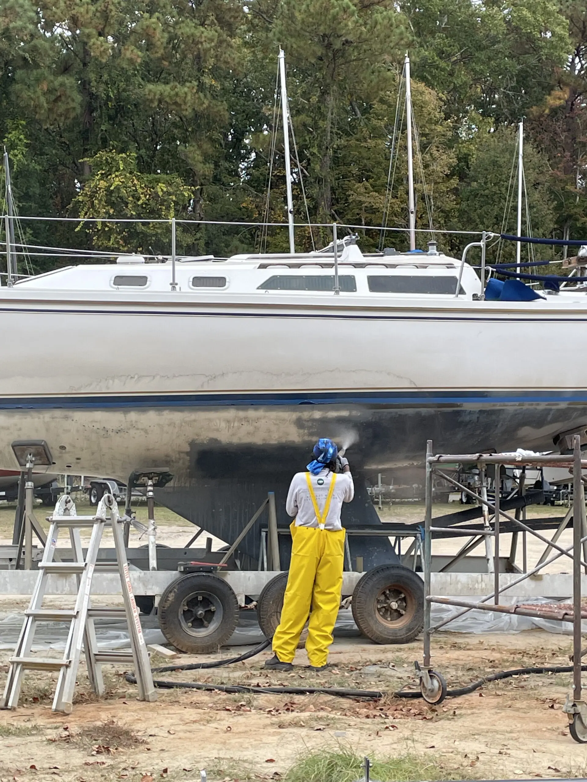 A man standing next to a boat on the ground.